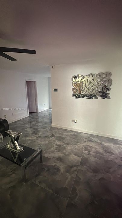 Polished concrete flooring, recessed wall lighting, and a ceiling fan with dark blades
