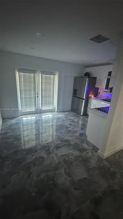 Glossy large format floor tiling, white French doors with integrated blinds, and recessed lighting