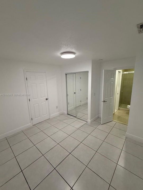 Ceramic tile flooring, mirrored closet doors, and recessed lighting