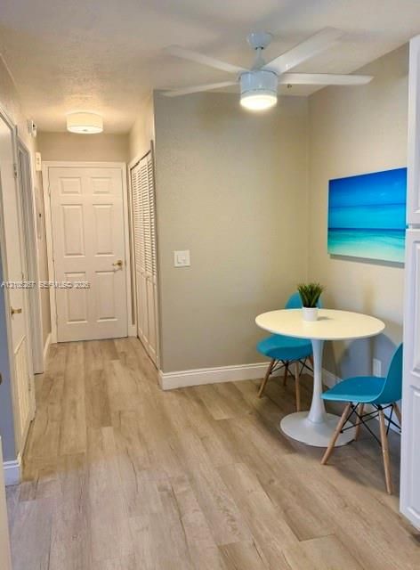 Wood-finish flooring throughout, complemented by a contemporary ceiling fan with integrated lighting