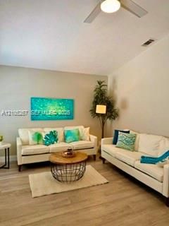 Wood-finish flooring throughout, ceiling fan with integrated lighting, and neutral wall tones