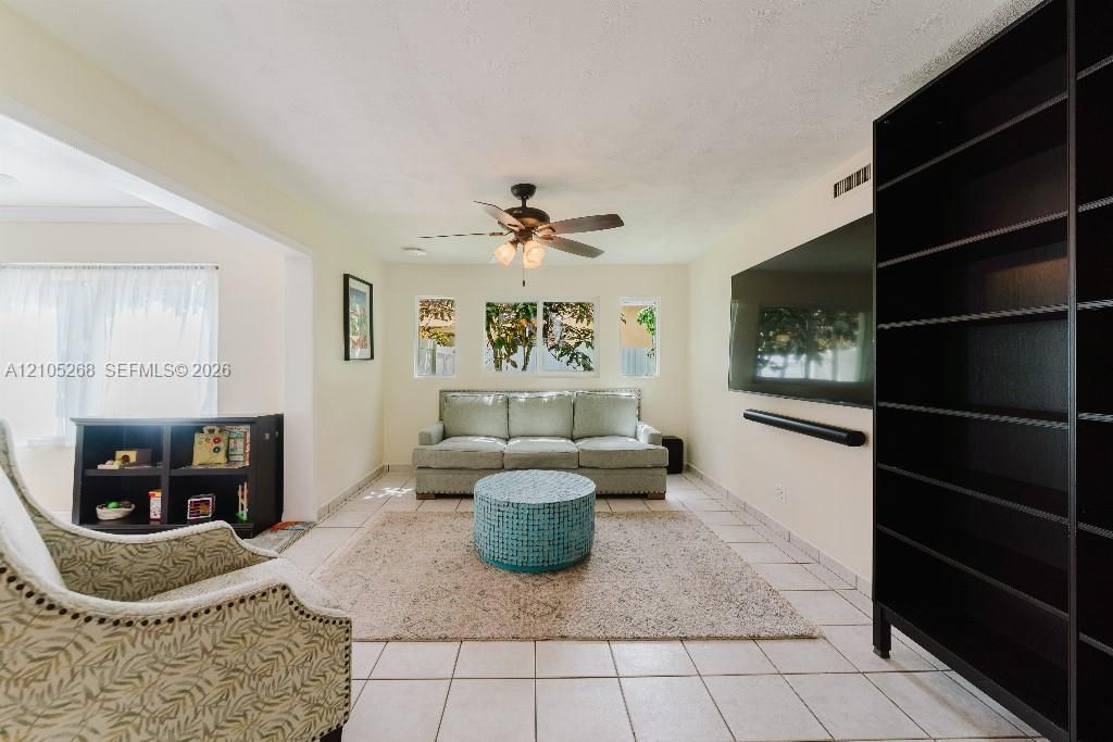 White tile flooring, ceiling fan, recessed lighting, and built-in shelving