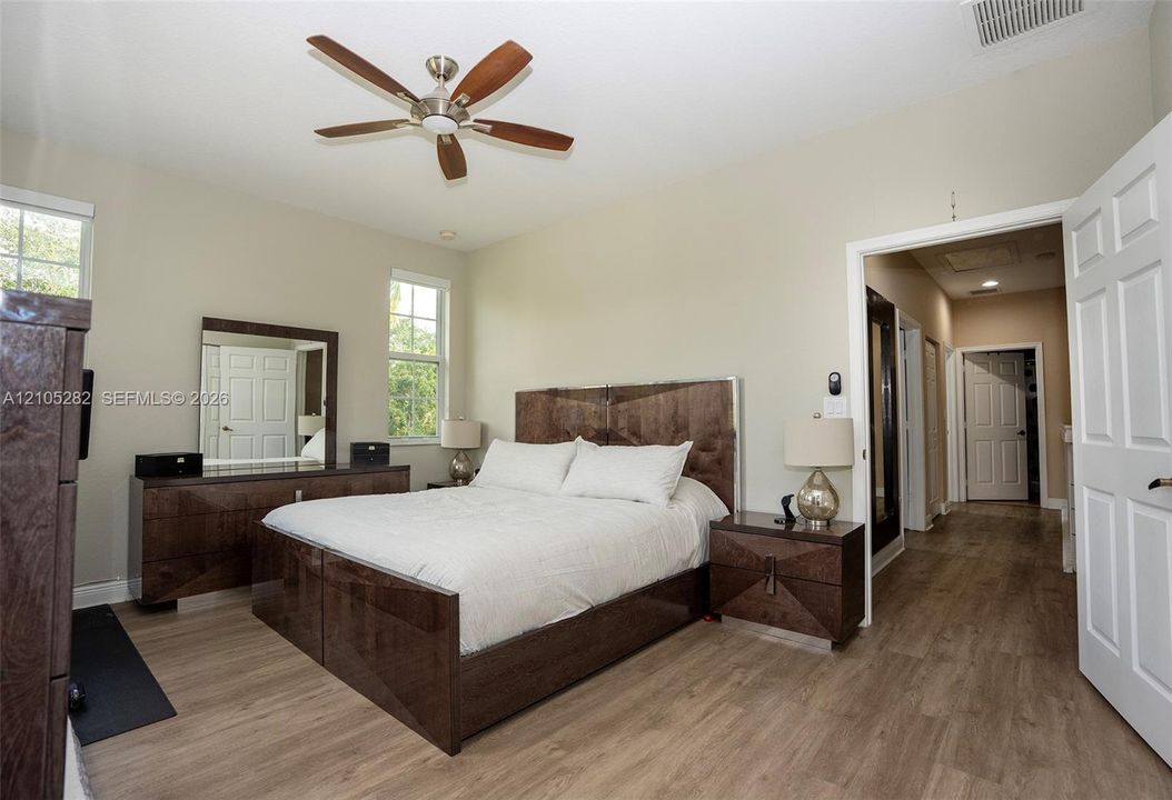Vaulted ceilings, wood-finish flooring, multi-pane windows, and a ceiling fan with integrated lighting