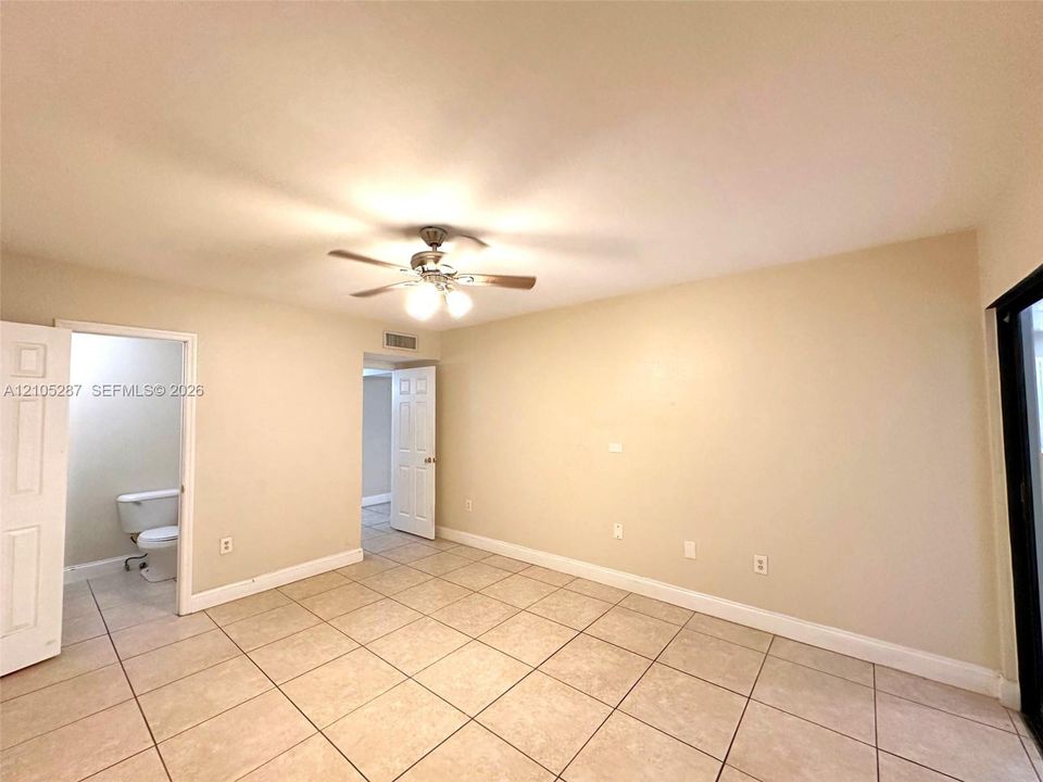 Tile flooring, ceiling fan with integrated lighting, and a sliding glass door