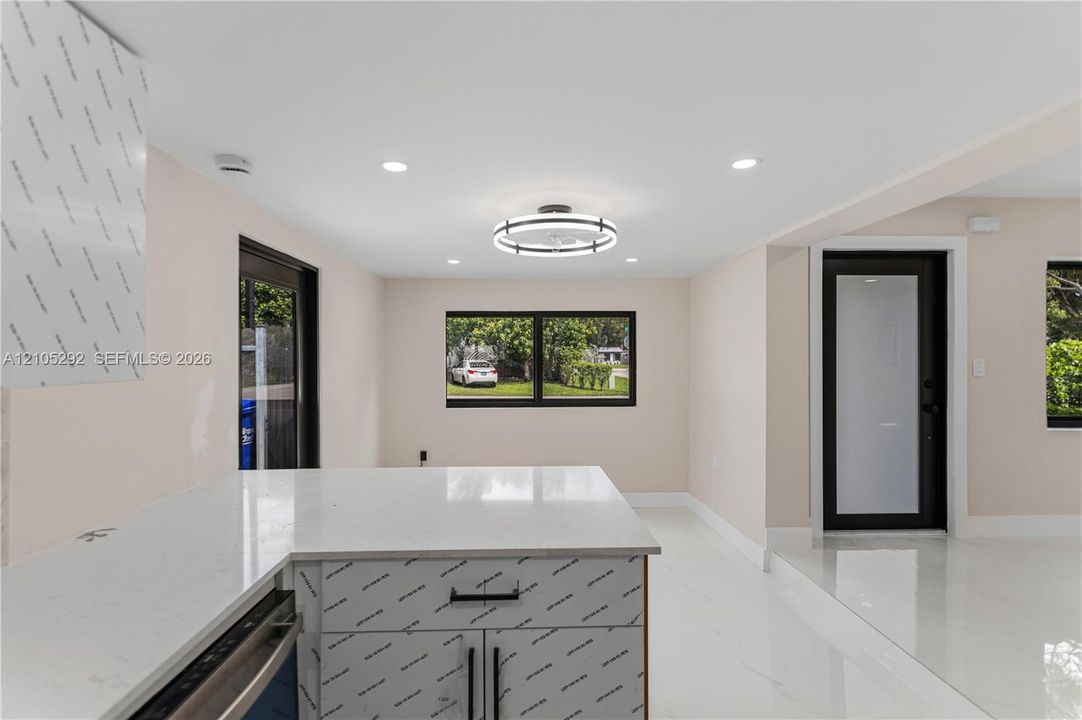 White countertop island with built-in cabinetry and matte black hardware