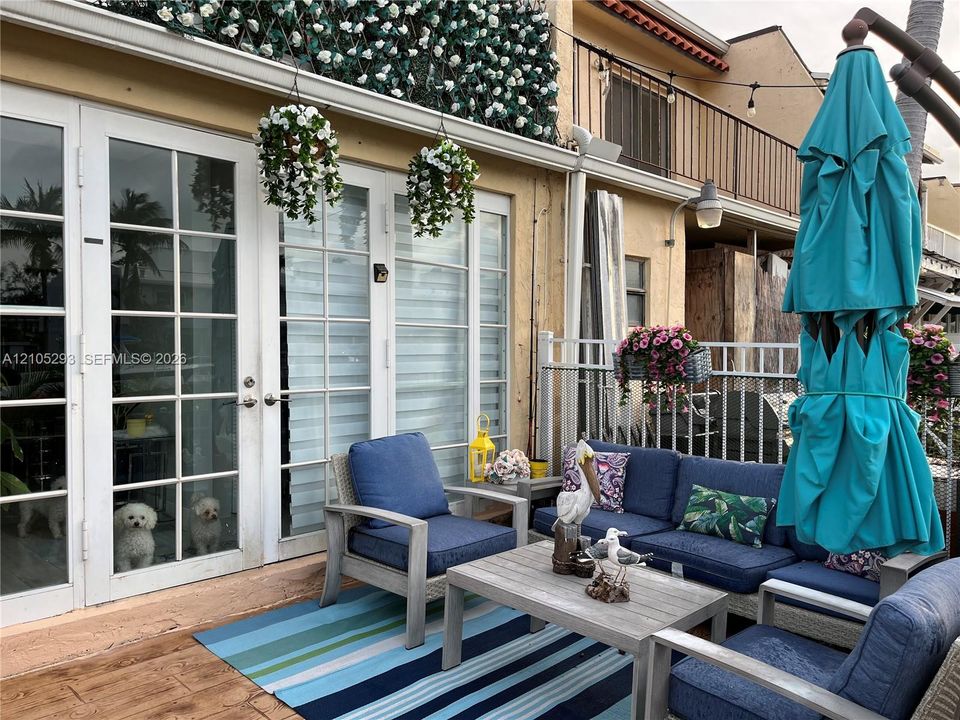 Patio space featuring double glass-paned doors, wood-finish flooring, and a metal perimeter railing