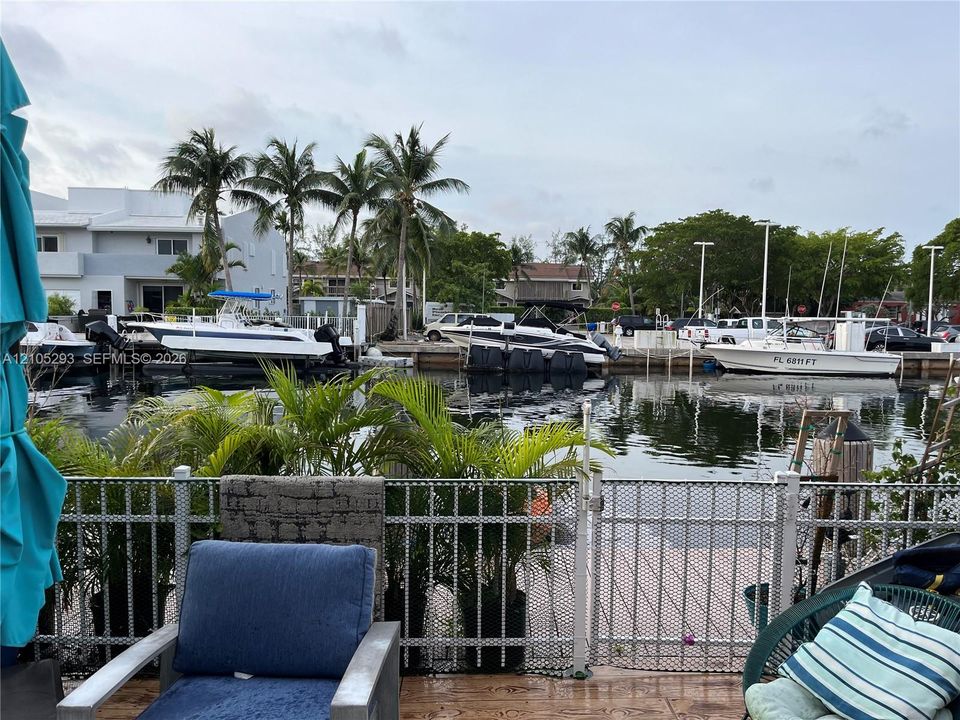 Waterfront property featuring a private boat slip, dockage with mooring posts, and metal perimeter fencing