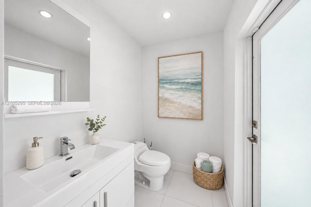 Minimalist bathroom featuring a white vanity with an integrated rectangular sink, chrome hardware, a wall-mounted mirror, recessed lighting, and large-format floor tile