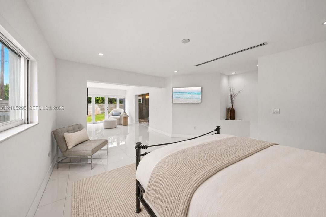 Interior space featuring large-format tile flooring, recessed ceiling lighting, a built-in architectural niche, and double glass-pane doors