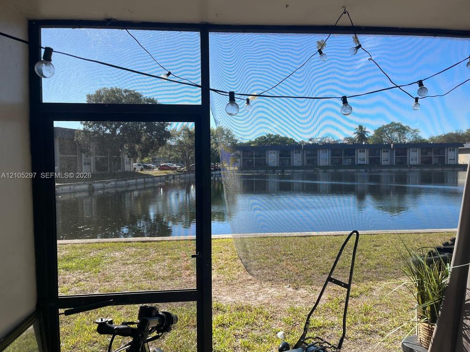 Screened enclosure featuring a water body beyond the property line