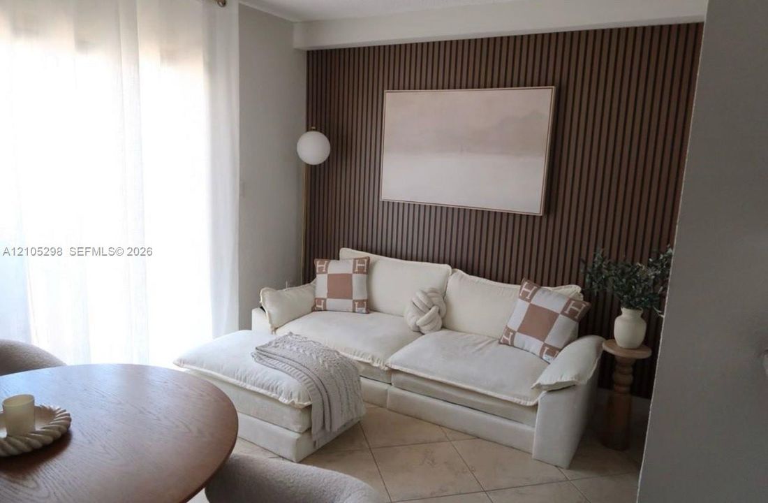 Accent wall with vertical wood paneling, globe wall sconce, and neutral tone flooring