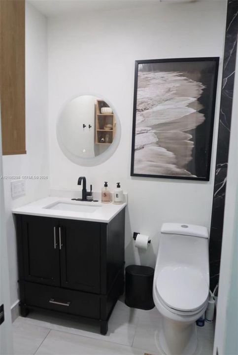 Vanity with a white countertop and black cabinetry