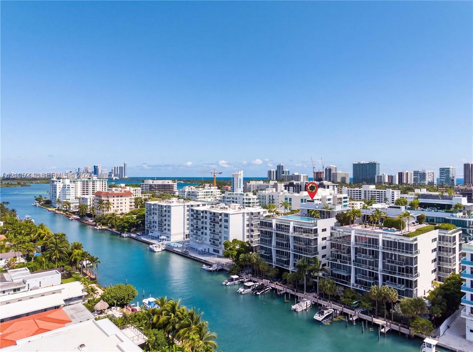 Waterfront high-rise building with a rooftop pool and multiple balconies overlooking the canal