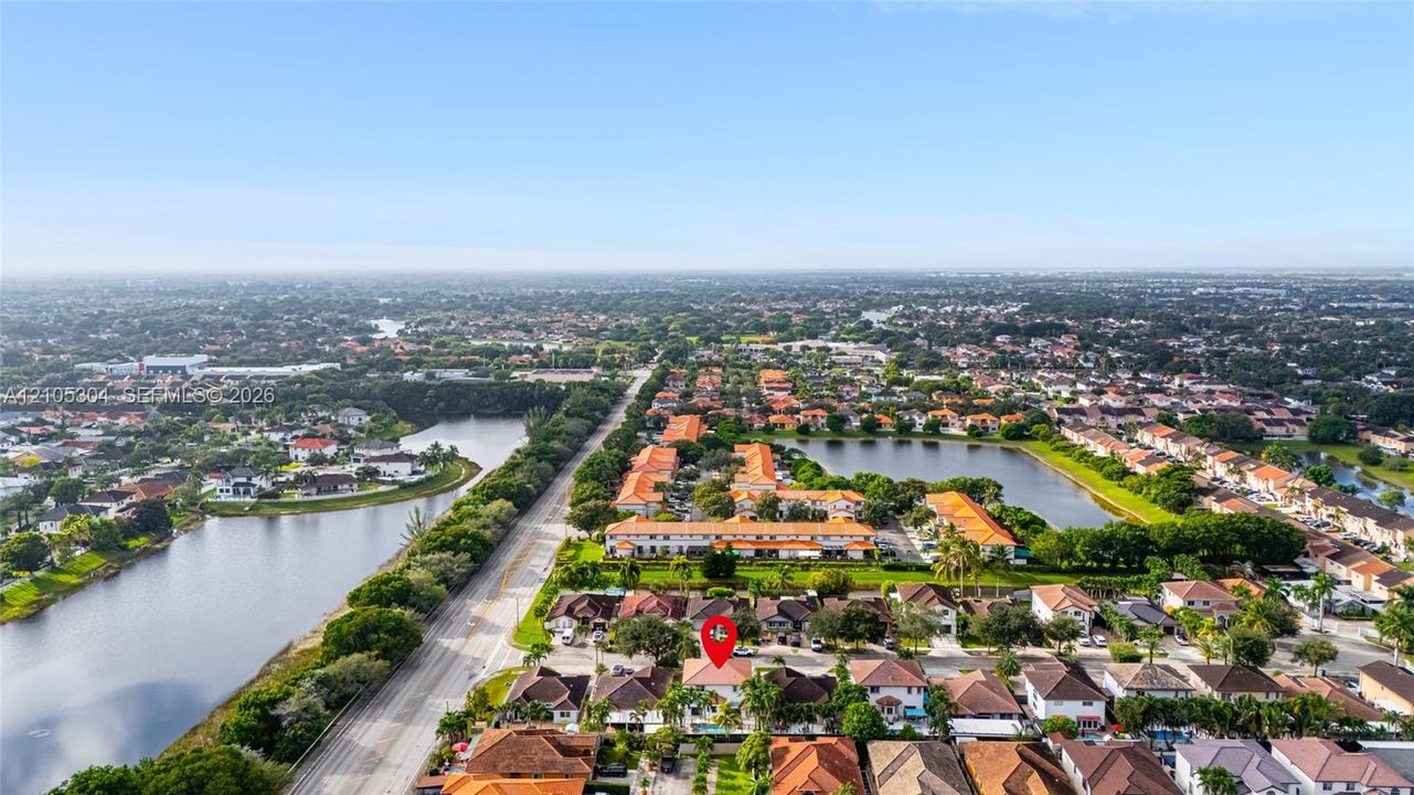 Aerial perspective of a residential property featuring a tiled roof, multi-car garage, and an in-ground swimming pool