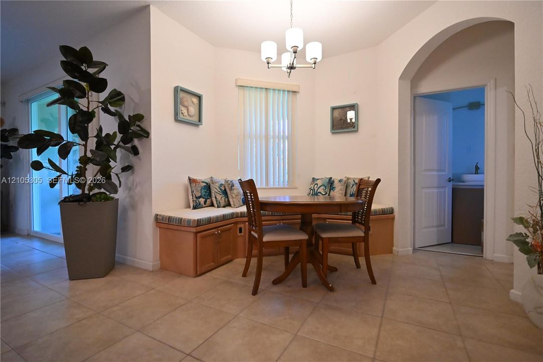 Tile flooring, built-in bench seating with storage, arched doorway, and sliding glass door