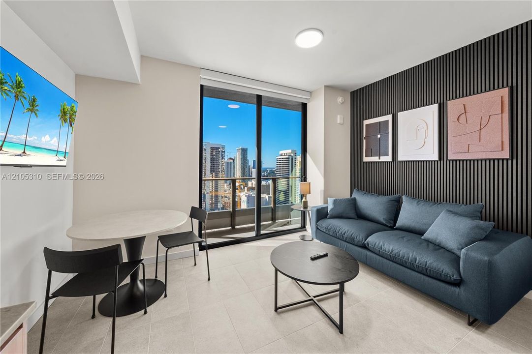 Floor-to-ceiling glass doors, high ceilings, contemporary accent wall, recessed lighting, and tile flooring