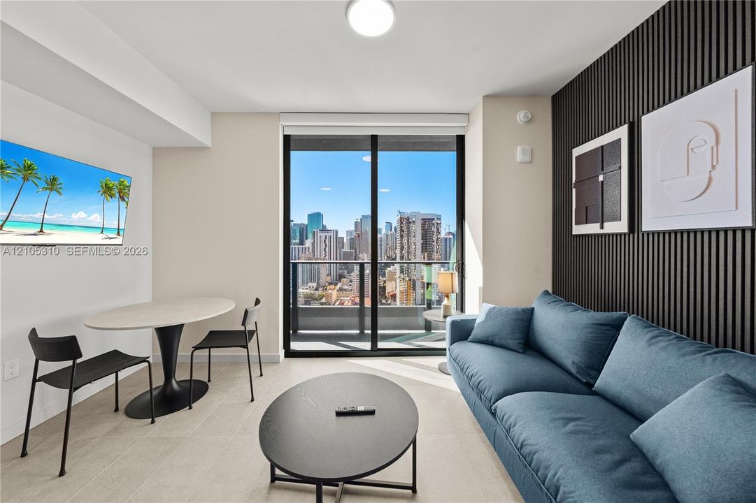 Full-height glass doors, cityscape scenery, recessed lighting, and a textured accent wall