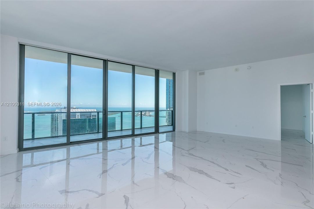Expansive room featuring large format tile flooring and floor-to-ceiling sliding glass doors