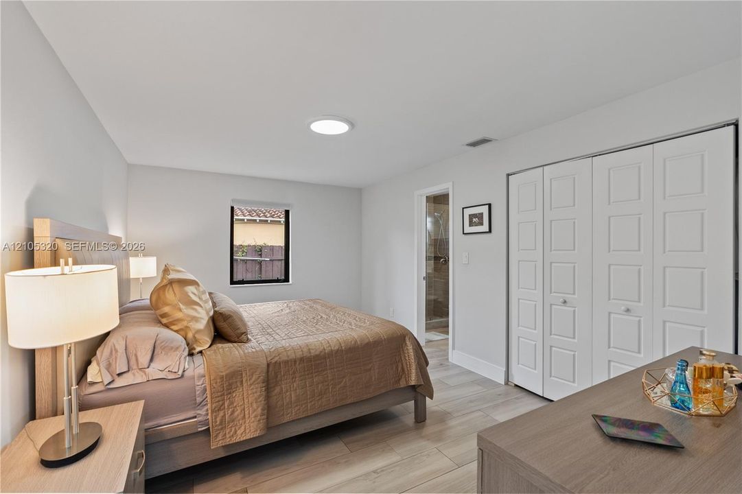 Wood-finish flooring, white walls, built-in closet with paneled doors, and a recessed ceiling light
