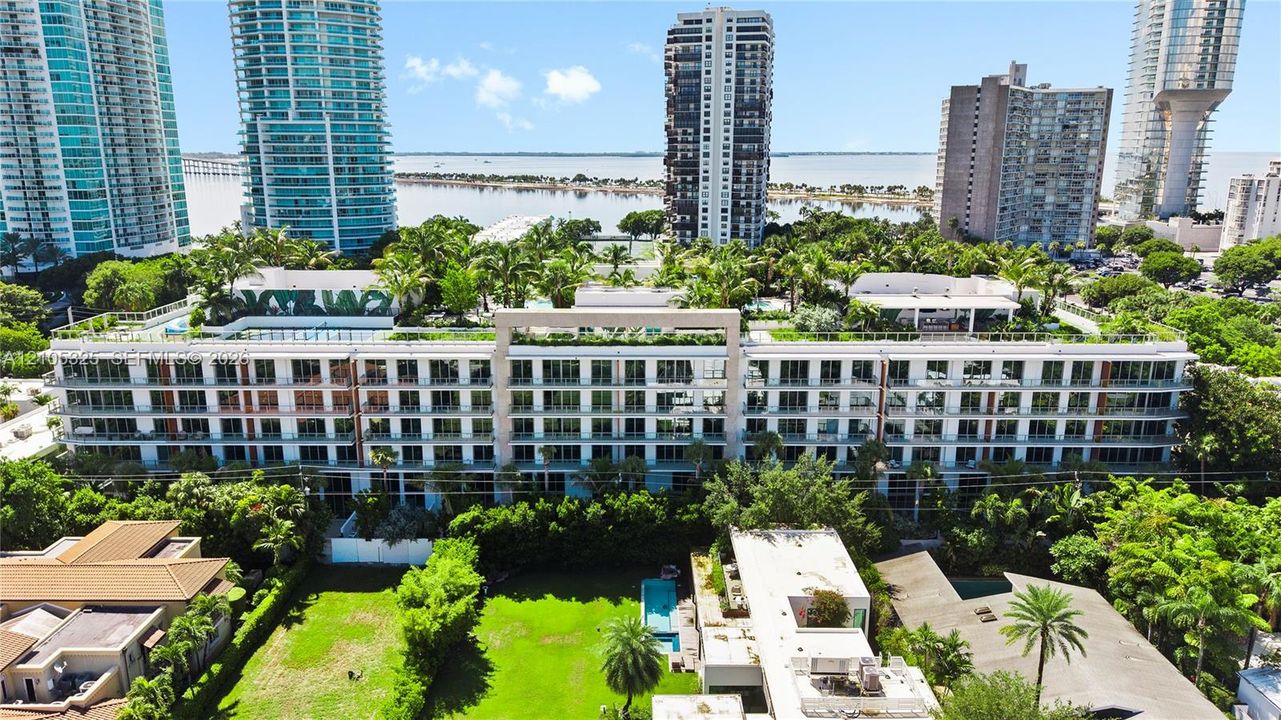 Modern multi-story building featuring multiple balconies and a flat roofline