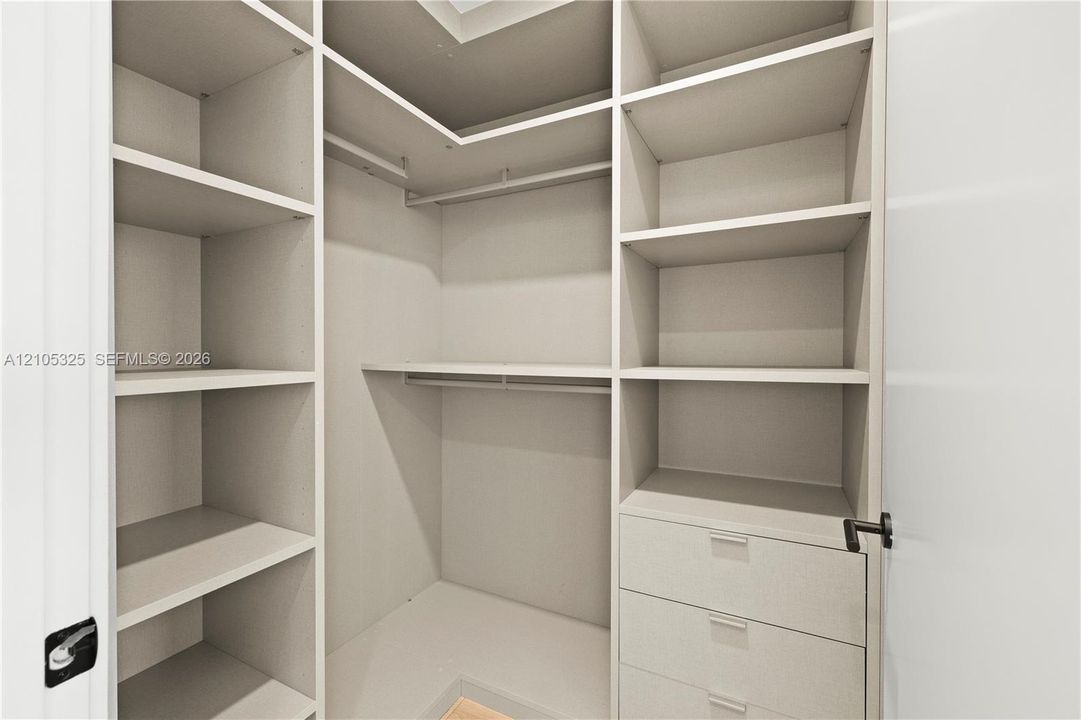 Built-in closet system featuring multiple shelves, hanging rods, and integrated drawers