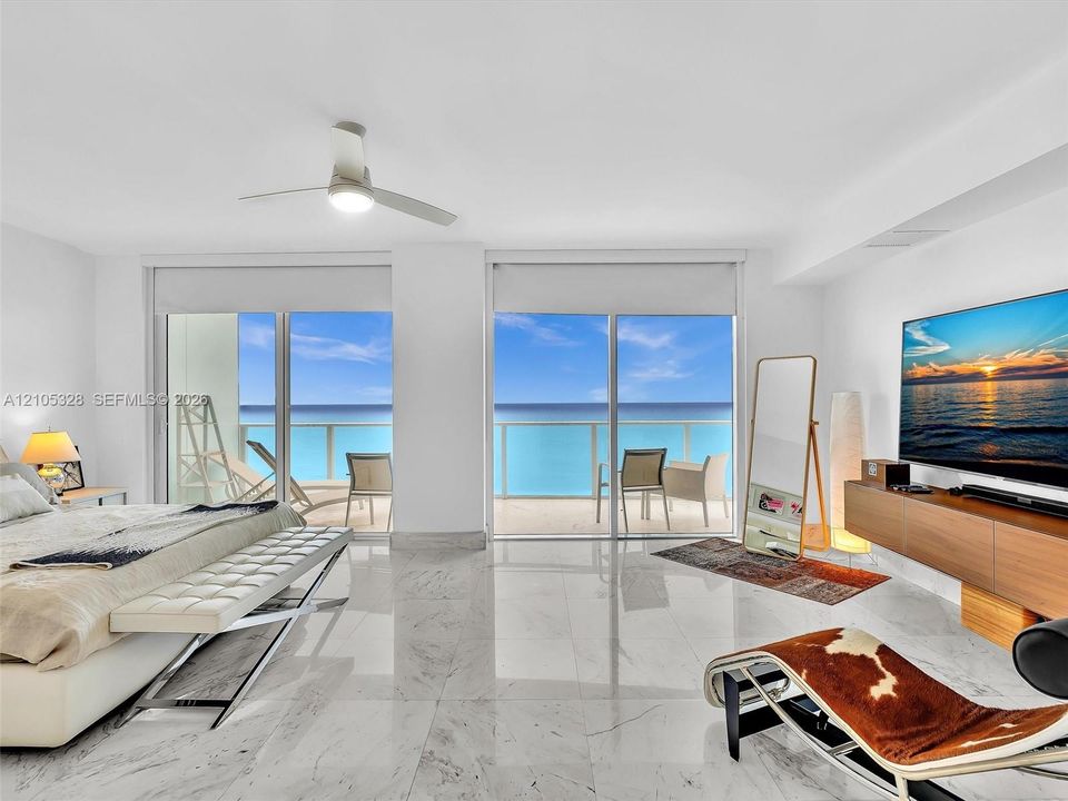 Wake up to breathtaking ocean views from the comfort of your bed in this spacious primary suite, featuring floor-to-ceiling sliding glass doors with direct access to a private balcony.