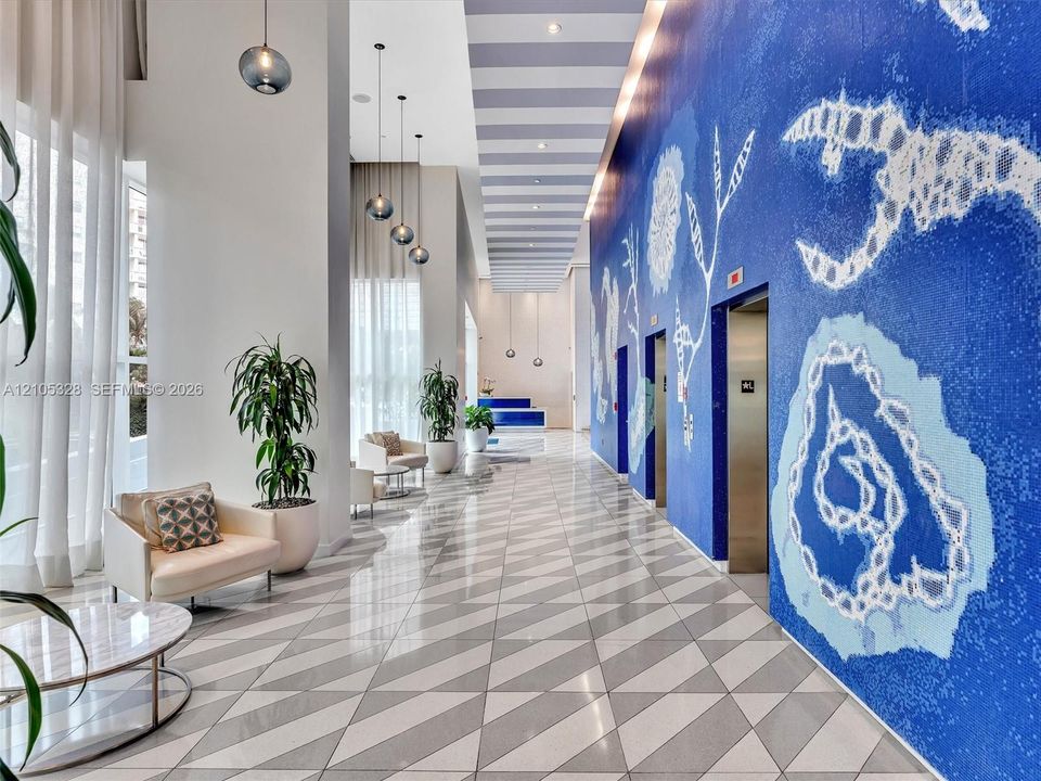 Step into an elegant, contemporary lobby with the intimate ambiance of a luxury boutique hotel, featuring distinctive designer finishes, stylish architectural details, sophisticated accent lighting, and a welcoming atmosphere.