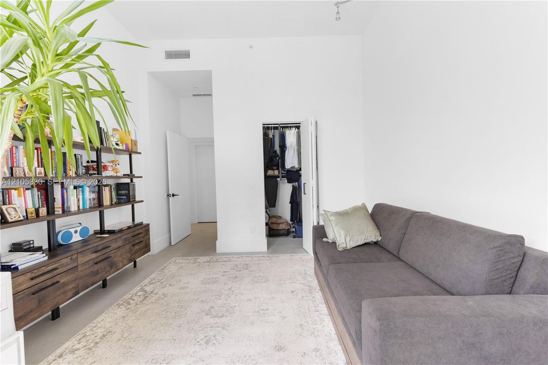 White interior walls with a built-in closet, high ceilings, and recessed lighting