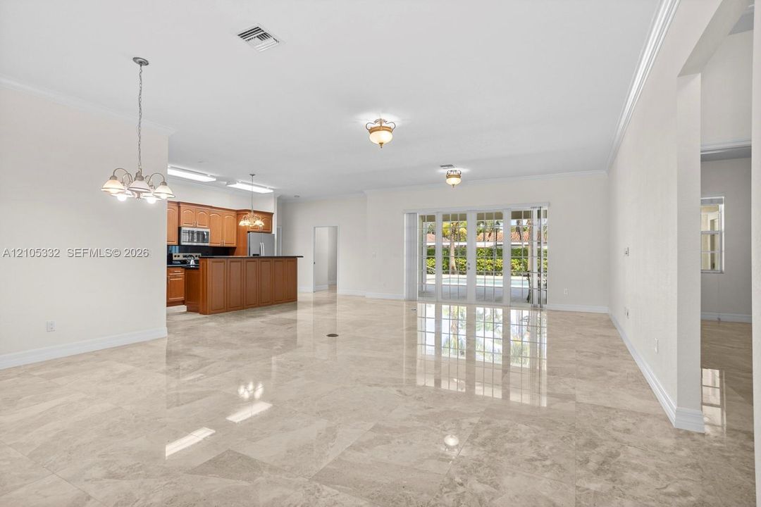 Light-toned tile flooring, white walls, and crown molding throughout