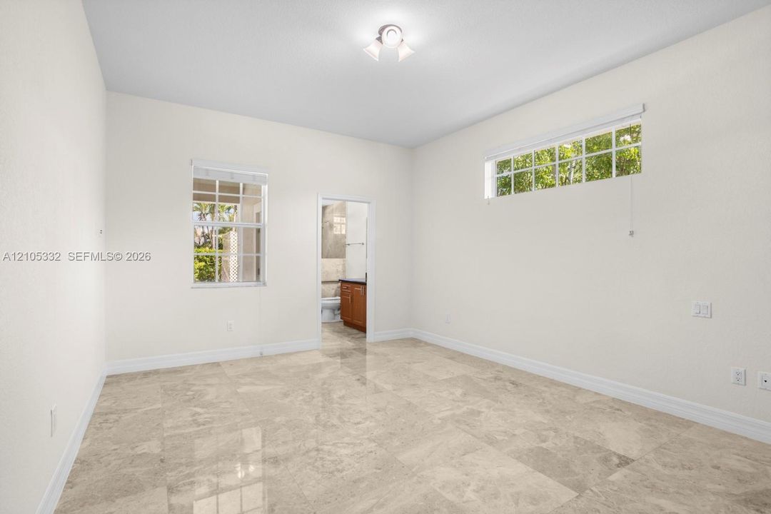 Light-toned tile flooring, white walls, two windows with blinds, recessed lighting fixture