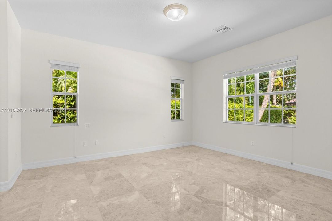 Polished tile flooring, multiple windows, overhead flush-mount lighting, and neutral wall tones