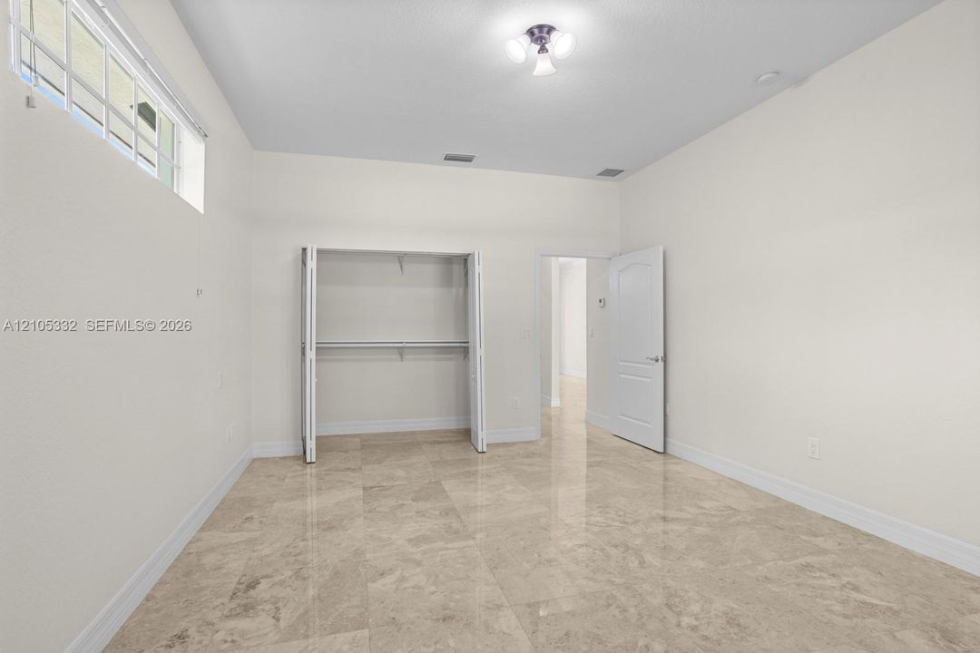 Recessed window, built-in closet with bi-fold doors, wood-finish flooring, and a flush mount ceiling light fixture