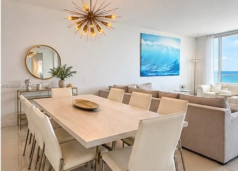 Spacious dining area with a modern sputnik chandelier, light wood-finish dining table, and tile flooring
