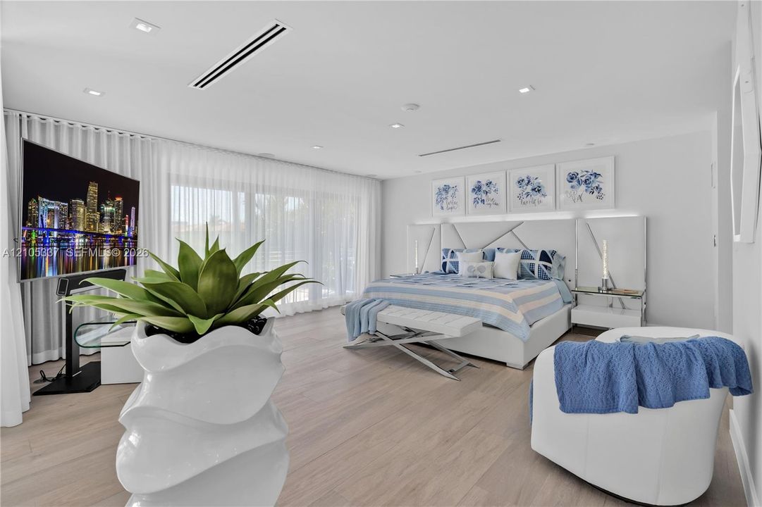 Wood-finish flooring, recessed lighting, integrated linear ceiling registers, and expansive wall-to-wall sliding glass doors