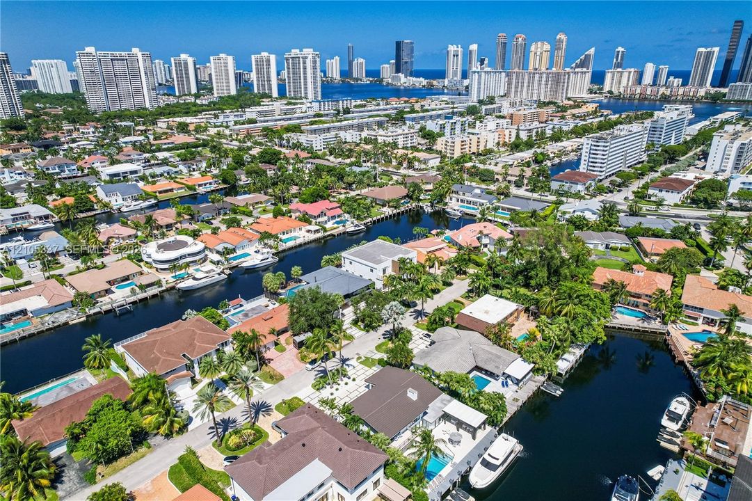 Aerial perspective of a coastal residential neighborhood featuring deep-water canal access, private boat docks, and established palm tree landscaping
