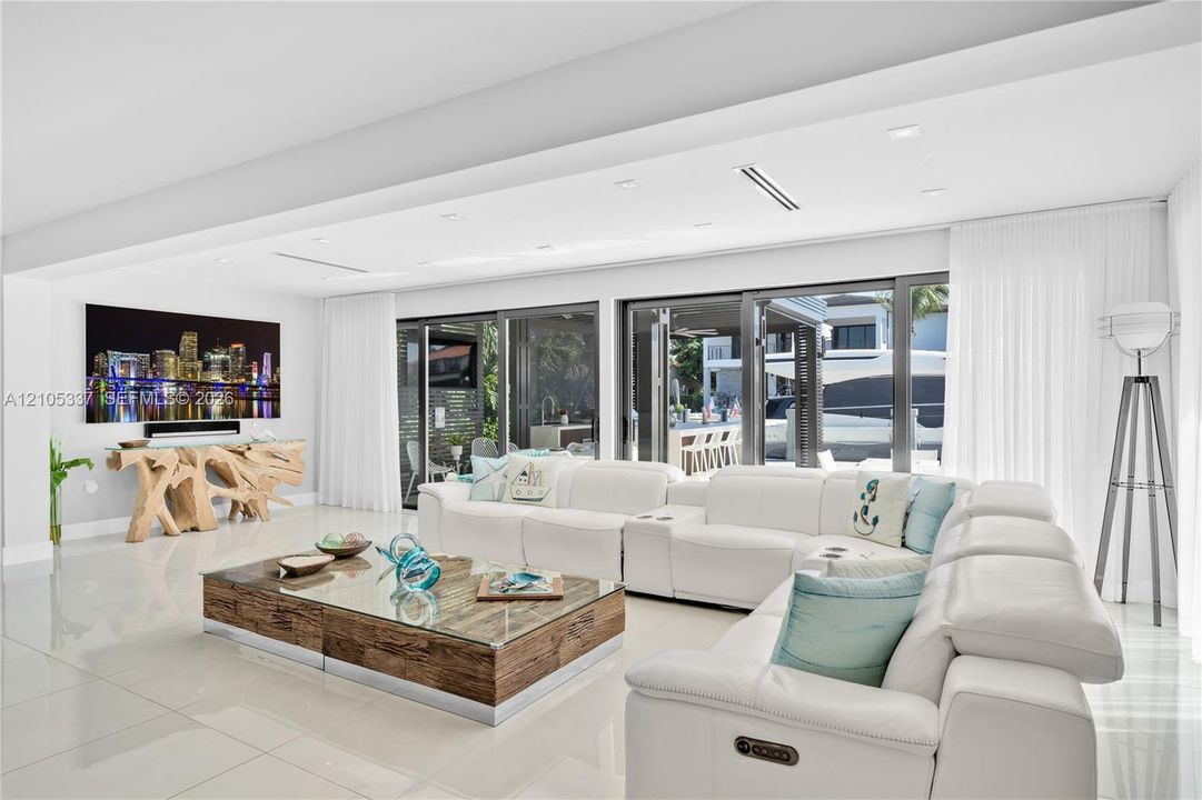 Open-concept interior featuring large-format polished tile flooring, recessed ceiling lighting, and multi-panel glass sliding doors