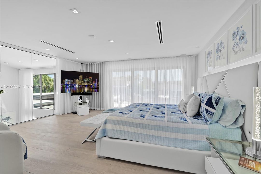 Interior space featuring wood-finish flooring, floor-to-ceiling glass wall, recessed lighting, and wall-to-wall drapery