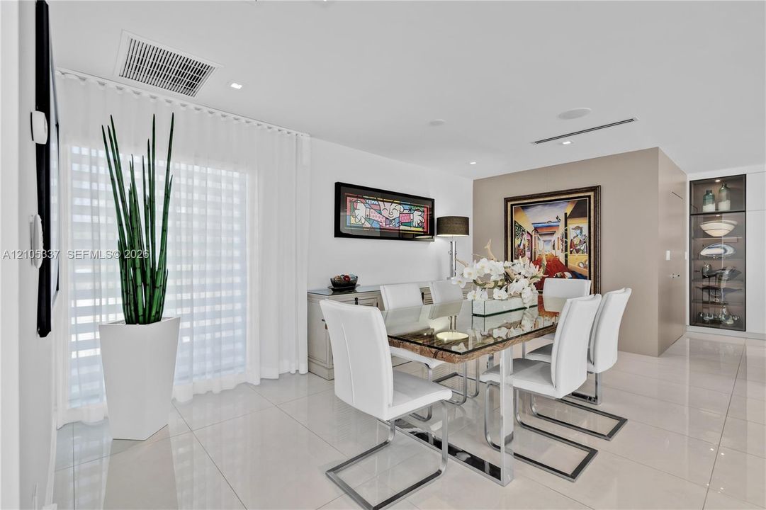 Large-format tile flooring, recessed ceiling lighting, and built-in glass-front display cabinetry