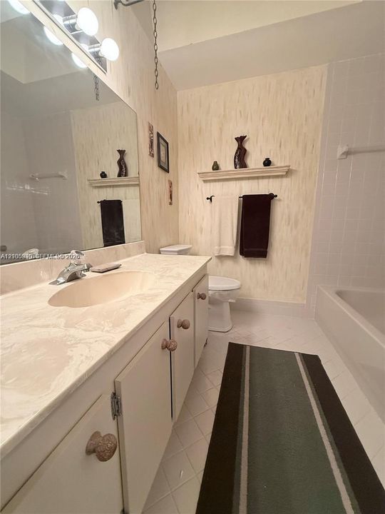 Vanity with an integrated sink, built-in cabinetry, and a full-width mirror