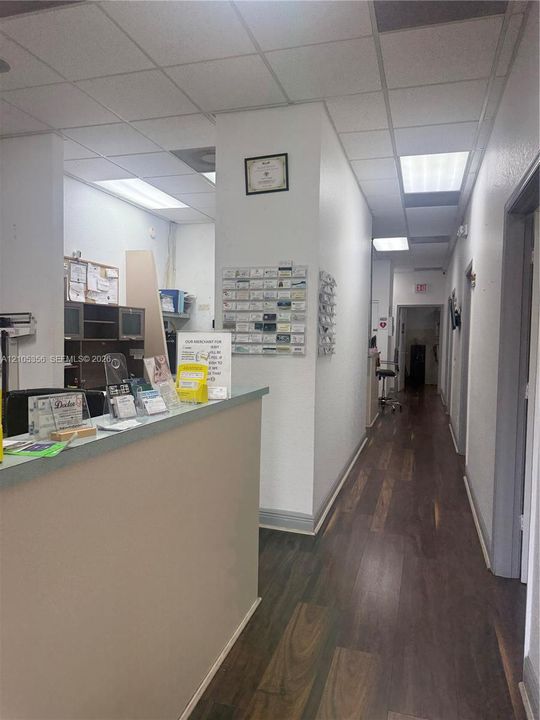 Reception area with wood-finish flooring, drop ceiling, and recessed lighting