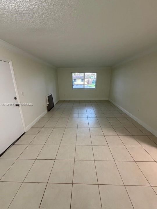 Large format tile flooring, neutral wall color, and a window with natural light