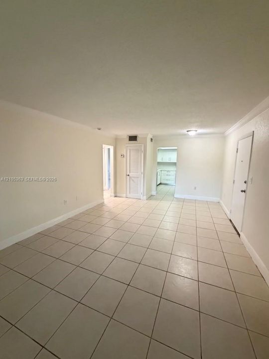 Neutral-toned tile flooring, white walls, and a ceiling-mounted light fixture