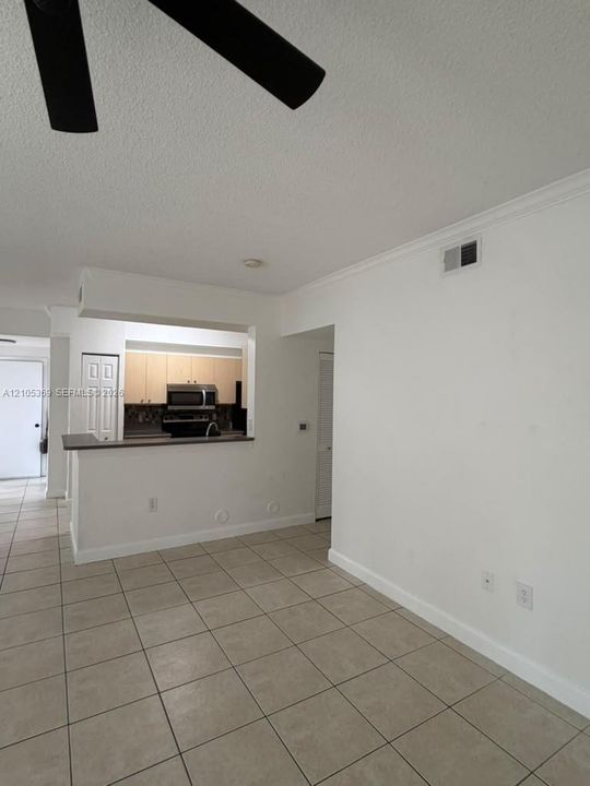 Tile flooring, ceiling fan, crown molding, pass-through kitchen, wood-finish cabinetry