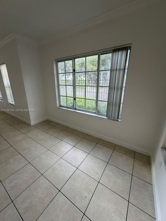Tile flooring and white walls with a large window