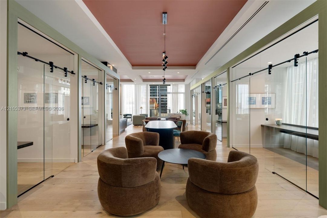 Light wood-finish flooring, glass sliding doors, recessed lighting, and a distinctive ceiling color palette