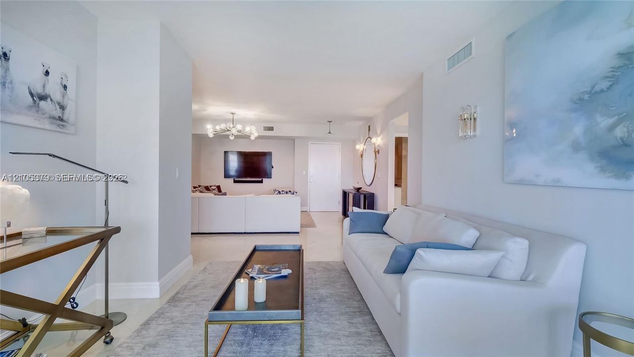 Recessed lighting, light-toned flooring, and an open-concept layout define this living space