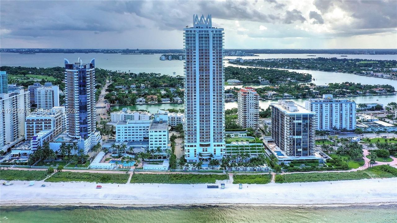 Expansive coastal property featuring high-rise buildings, waterfront access, a sandy beach, and surrounding waterways