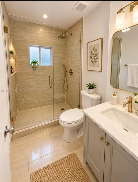 Shower with glass enclosure, gold-finish fixtures, and built-in shelving