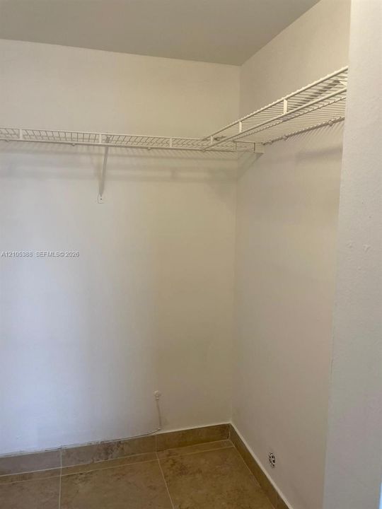 White wire shelving system, light-colored tile flooring, and neutral wall tones