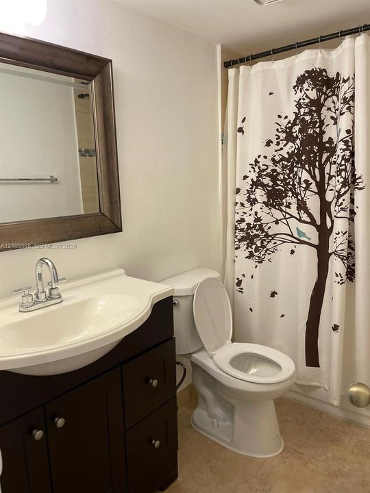 Vanity with integrated sink, framed mirror, and chrome fixtures